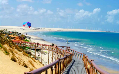 Wooden walkway overlooking Lagoinha Beach with parasailing and ocean view, Fortaleza.