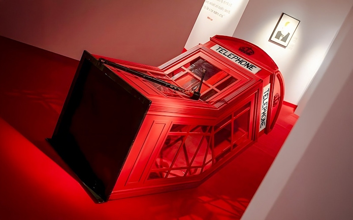 Red telephone booth installation at Banksy Limitless Exhibition.
