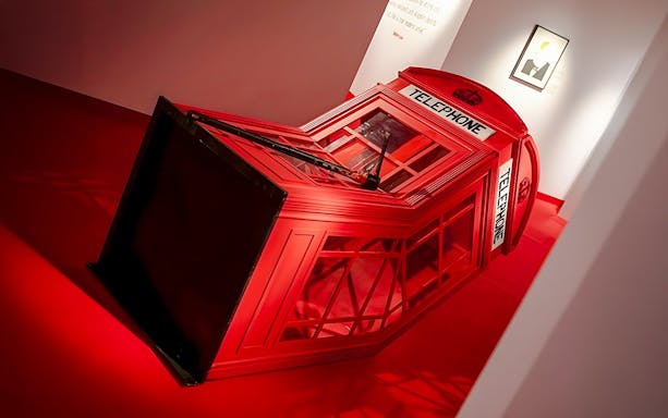 Red telephone booth installation at Banksy Limitless Exhibition.