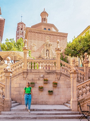 Visitor walking near historic architecture in Poble Espanyol, Barcelona.
