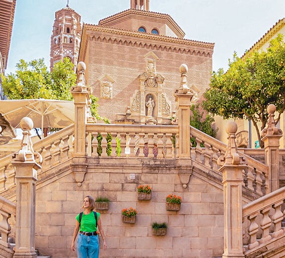 Visitor walking near historic architecture in Poble Espanyol, Barcelona.