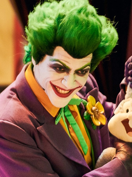 Character in colorful costume holding a plush toy at Warner Bros. World Abu Dhabi.