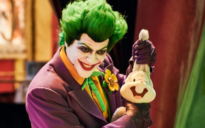 Character in colorful costume holding a plush toy at Warner Bros. World Abu Dhabi.