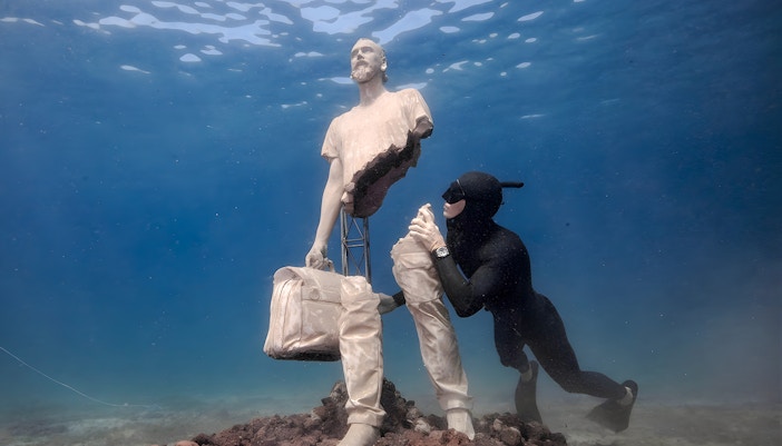 Diver exploring statue in Underwater Museum of Marseille.