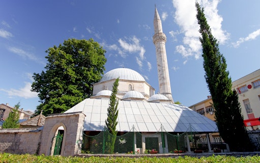 Mostar mosque with minaret under blue sky on Mostar and Kravice Falls day tour.