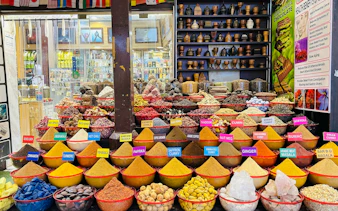 Spice market display with colorful spices and herbs in Dubai during a city tour from Abu Dhabi.