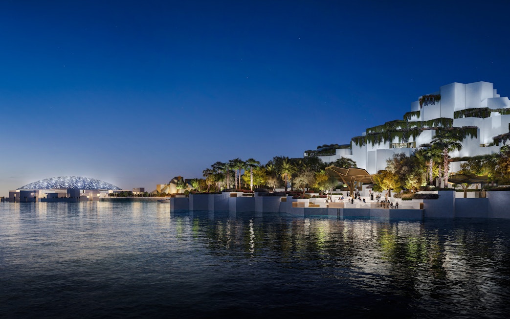 Aerial view of the National History Museum Abu Dhabi illuminated at night.