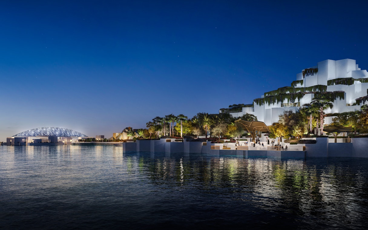 Aerial view of the National History Museum Abu Dhabi illuminated at night.