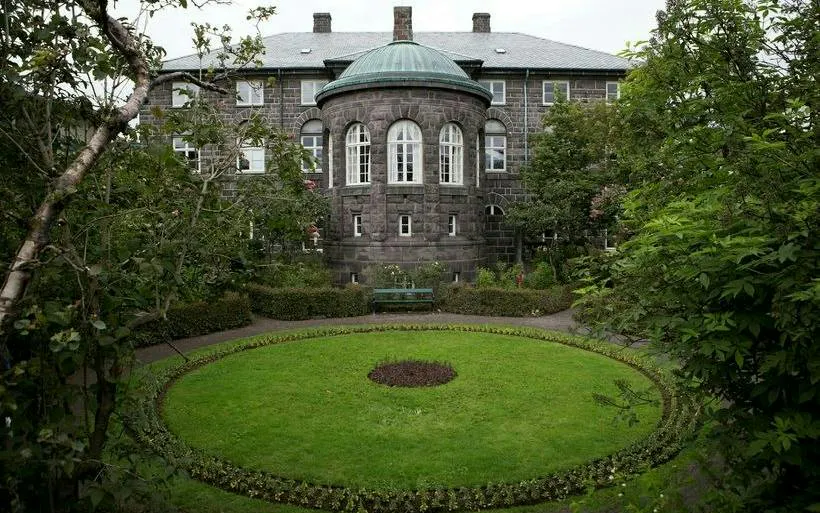 Historic building with a circular garden in Reykjavik, part of the self-guided city exploration game.