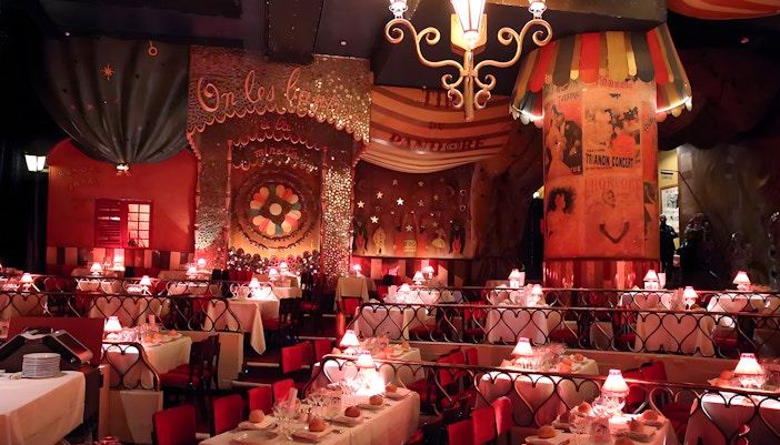 Moulin Rouge tables set for dinner with stage view in Paris, France.
