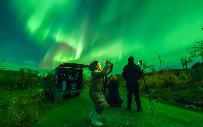 Tourists photographing the Northern Lights in Tromso, Norway.