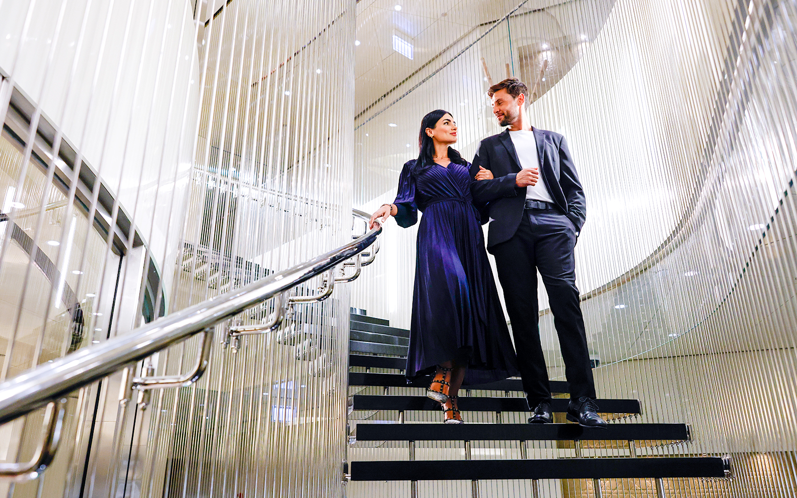 Couple walking down elegant staircase at Burj Khalifa Level 152 Lounge.