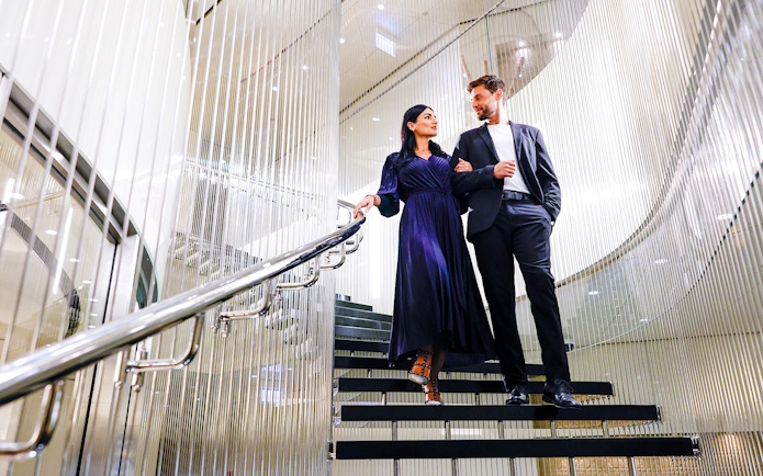 Couple walking down elegant staircase at Burj Khalifa Level 152 Lounge.