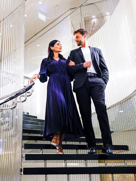 Couple walking down elegant staircase at Burj Khalifa Level 152 Lounge.