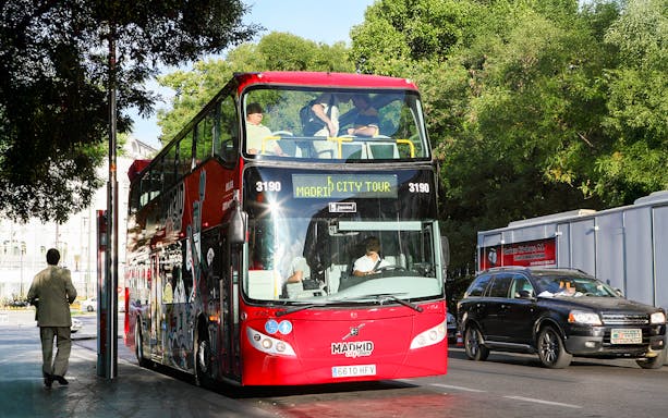Red double-decker bus for Madrid Hop On Hop Off tour parked on a city street.