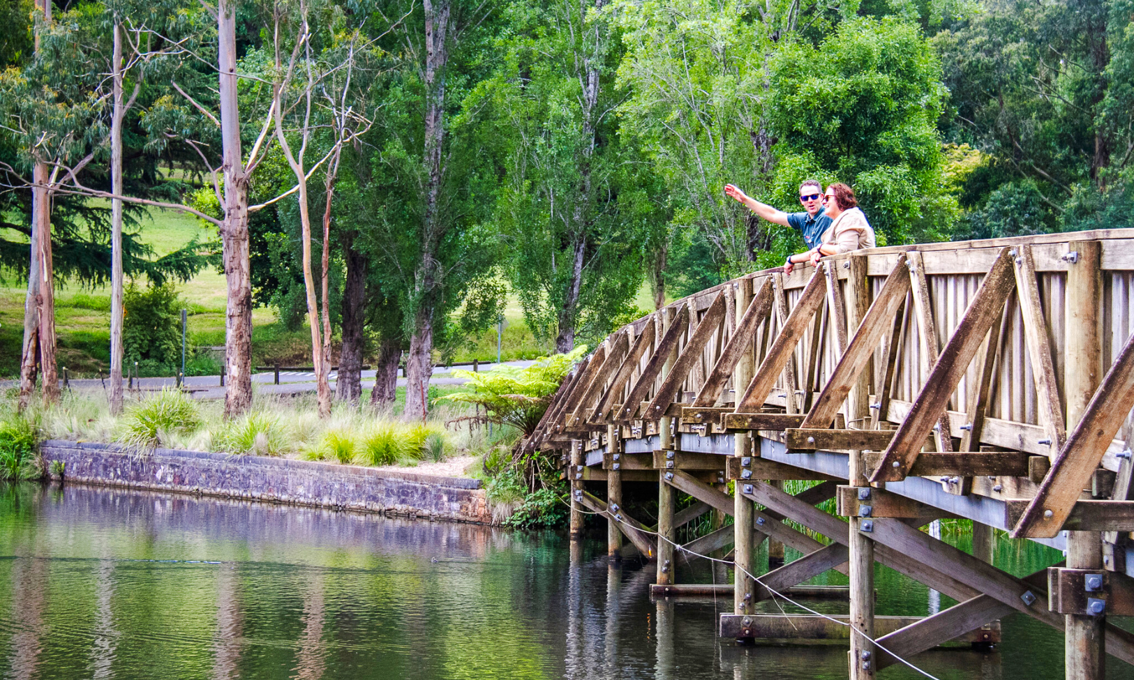 Couple on Lakeside discovery walk bridge, part of Puffing Billy tour, Melbourne.