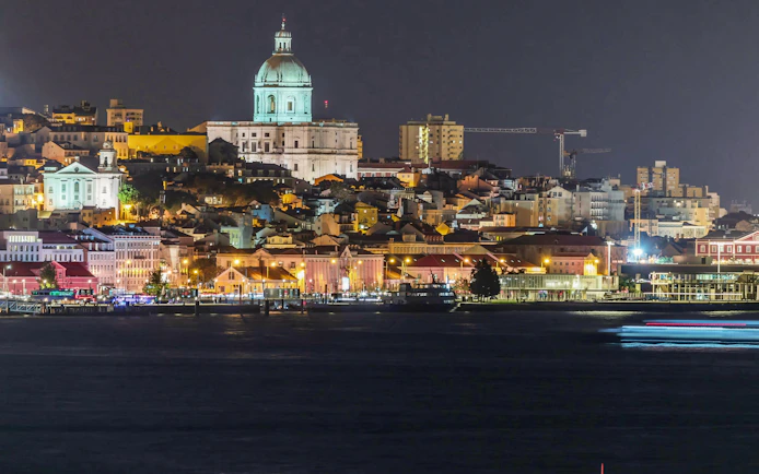 Lisbon's historic center at night with the illuminated National Pantheon.