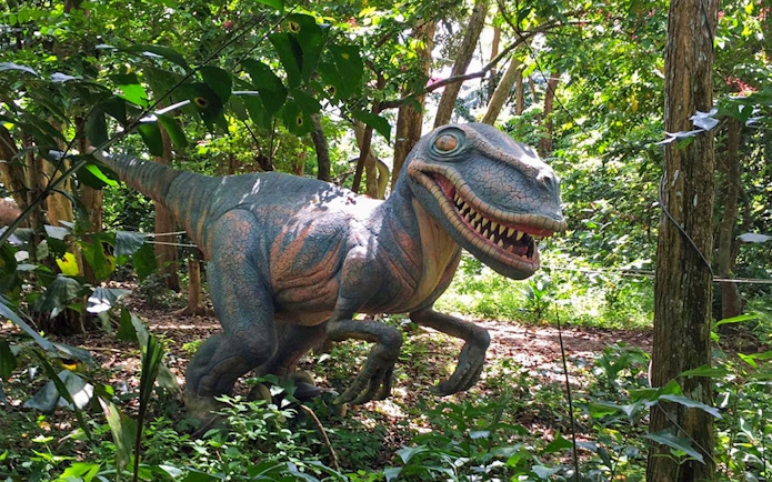 Dinosaur statue in forest setting at PD Ostrich Show Farm.