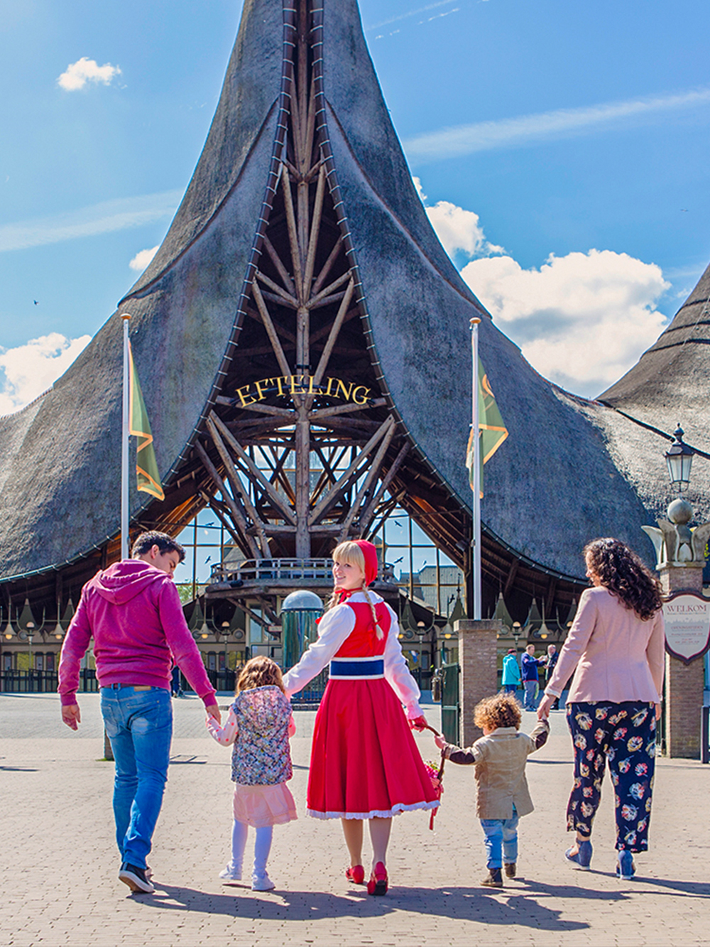 Family entering Efteling Theme Park under iconic entrance in the Netherlands.