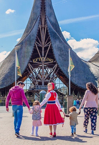 Family entering Efteling Theme Park under iconic entrance in the Netherlands.