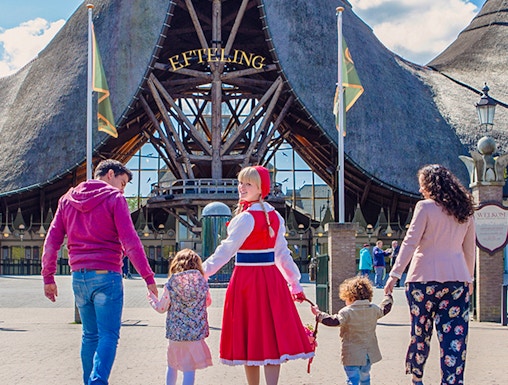 Family entering Efteling Theme Park under iconic entrance in the Netherlands.