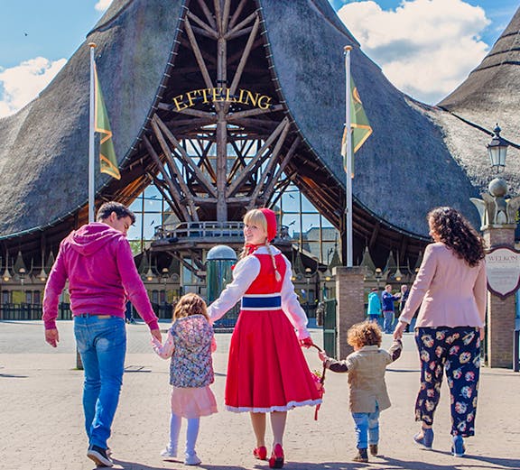 Family entering Efteling Theme Park under iconic entrance in the Netherlands.