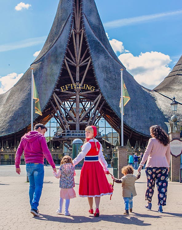 Family entering Efteling Theme Park under iconic entrance in the Netherlands.