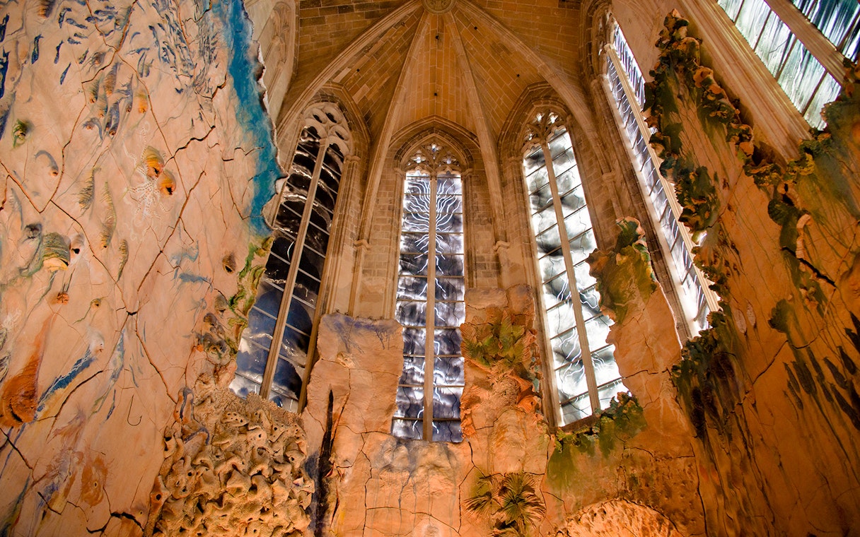 Mallorca Cathedral interior with intricate stained glass windows and detailed wall carvings.