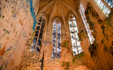Mallorca Cathedral interior with intricate stained glass windows and detailed wall carvings.