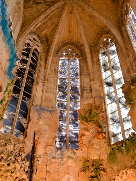 Mallorca Cathedral interior with intricate stained glass windows and detailed wall carvings.