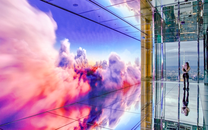 Interior of SUMMIT One Vanderbilt observation deck with mirrored floors and digital cloud display, New York City.