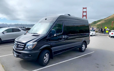 Tour van parked near Golden Gate Bridge for Alcatraz, Muir Woods, and Sausalito tour.