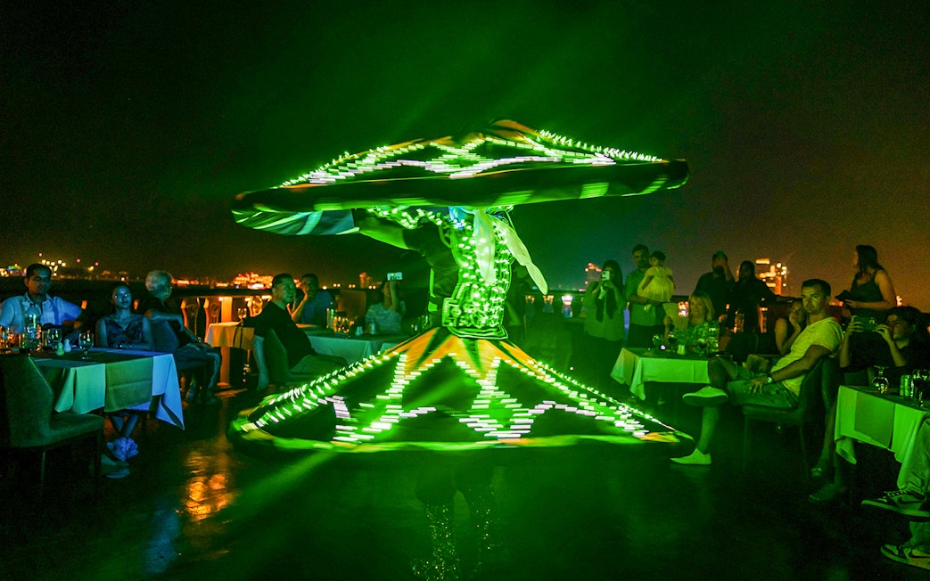 Dancer performing with LED lights on Alexandra Dhow Cruise, Dubai Marina.