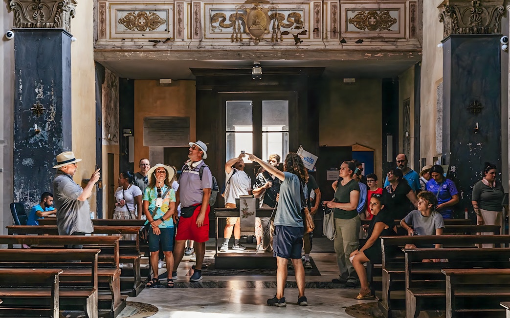 Tour group exploring Roman basilica interior on Appian Way.