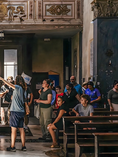 Tour group exploring Roman basilica interior on Appian Way.