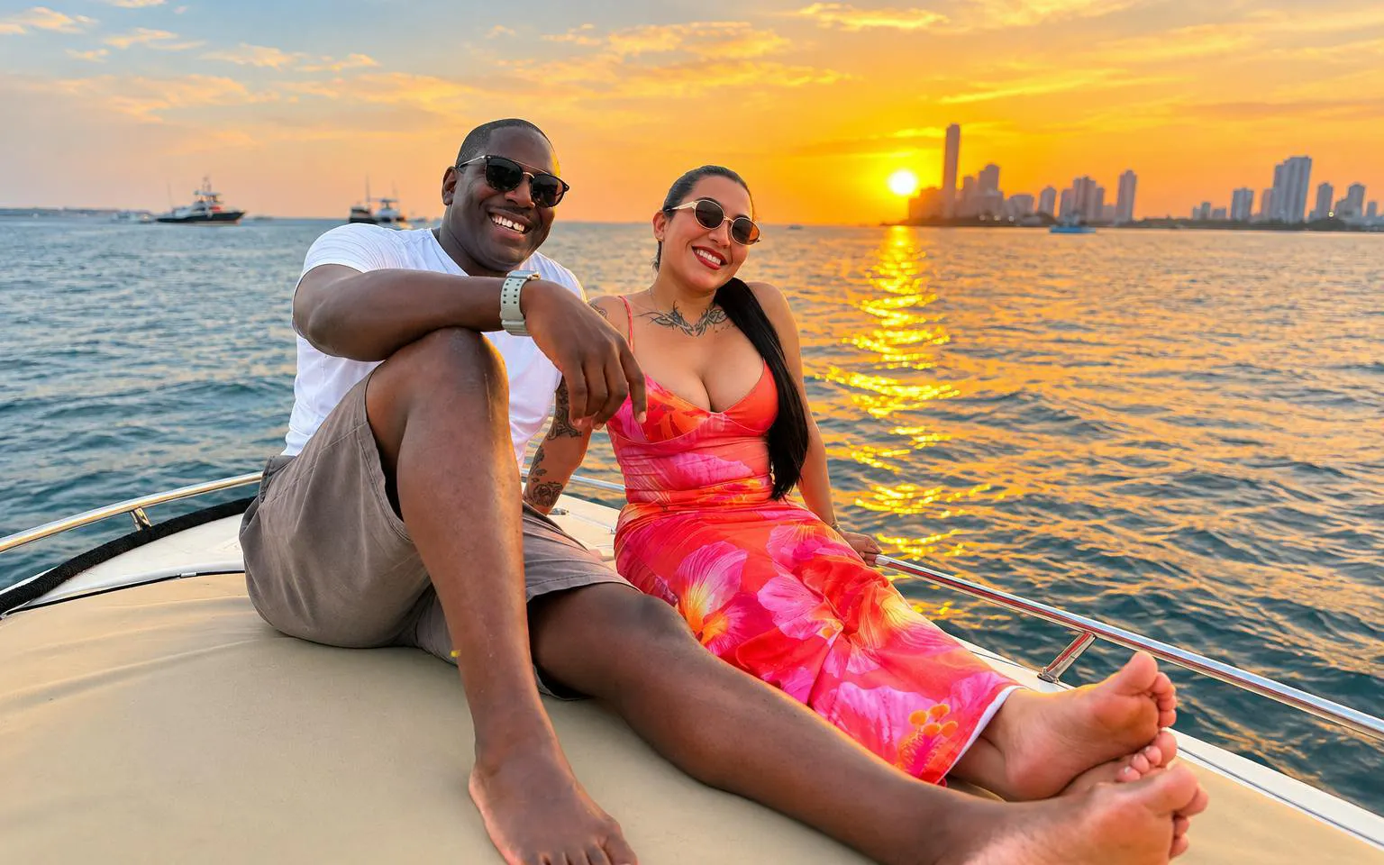 Couple enjoying a sunset cruise in Cartagena with city skyline in the background.