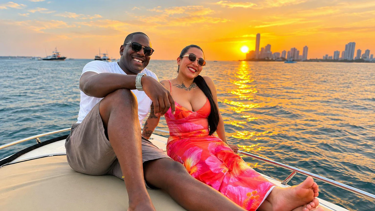 Couple enjoying a sunset cruise in Cartagena with city skyline in the background.