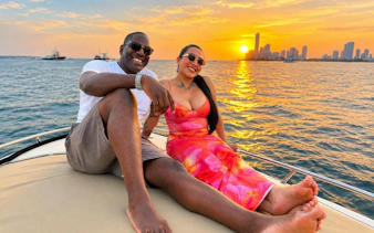 Couple enjoying a sunset cruise in Cartagena with city skyline in the background.
