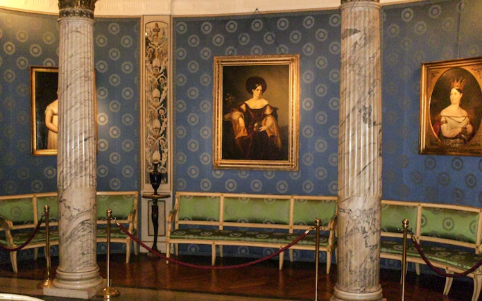 La Scala interior with paintings and marble columns on guided tour.