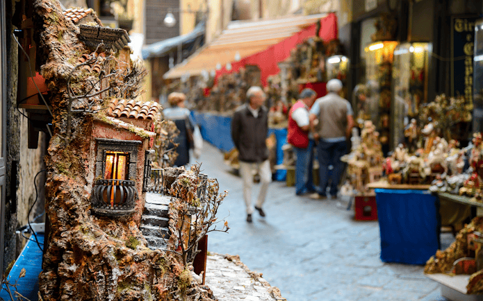 Street market in Naples with miniature house displays during guided tour.