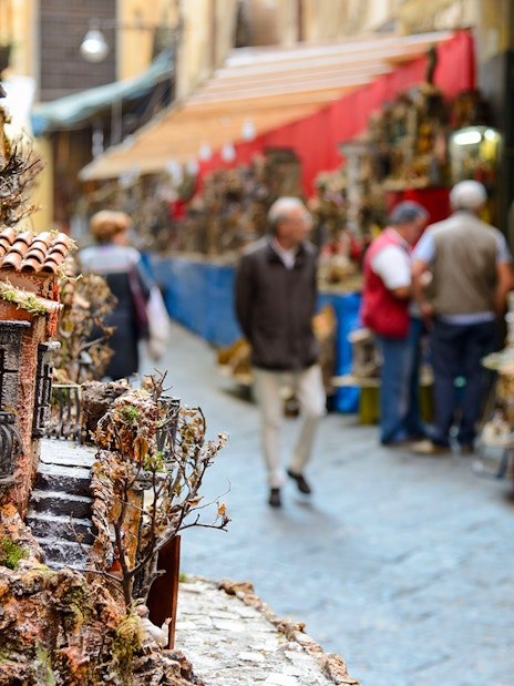 Street market in Naples with miniature house displays during guided tour.