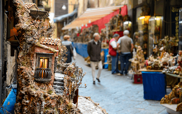 Street market in Naples with miniature house displays during guided tour.