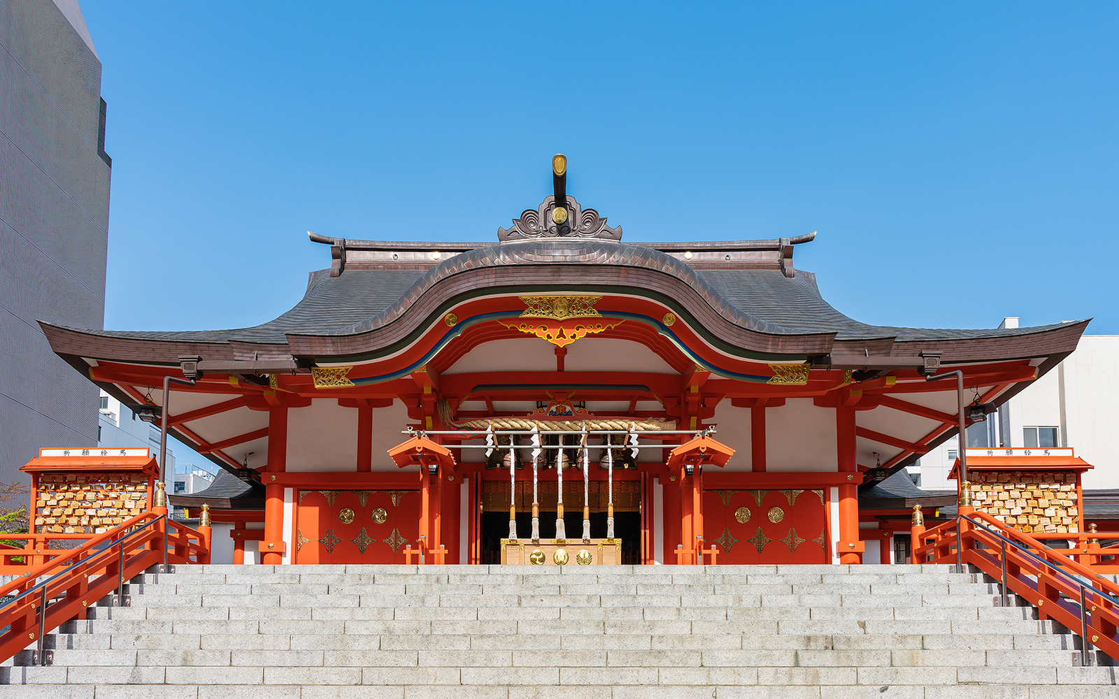 Red - orange coloured Hanazono-jinja Shrine, led by a stair pathway in summer