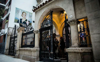 Entrance of Museo Evita in Palermo, Buenos Aires, with visitors and a poster of Eva Perón.