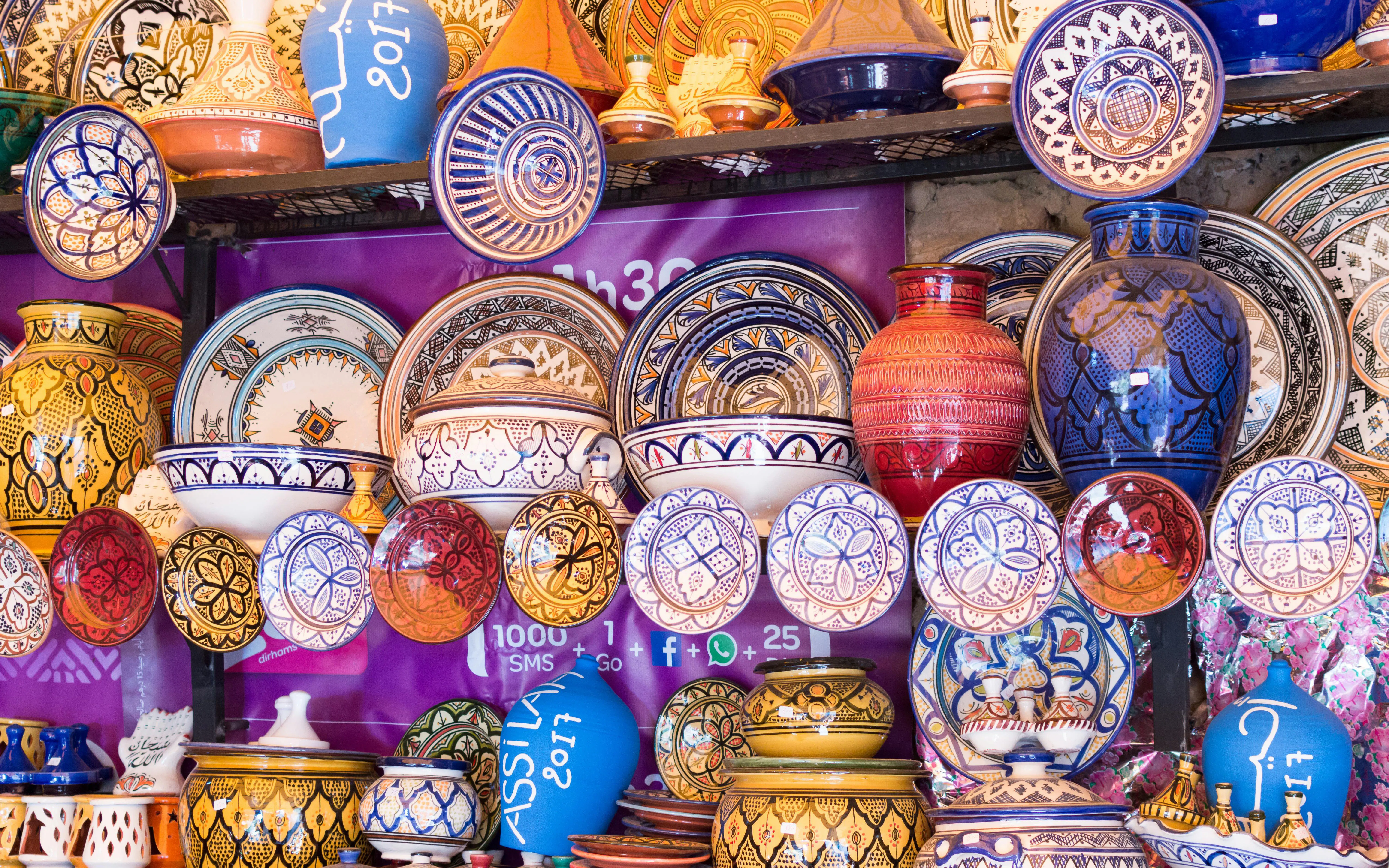 Moroccan ceramics display with colorful plates and vases in traditional patterns.