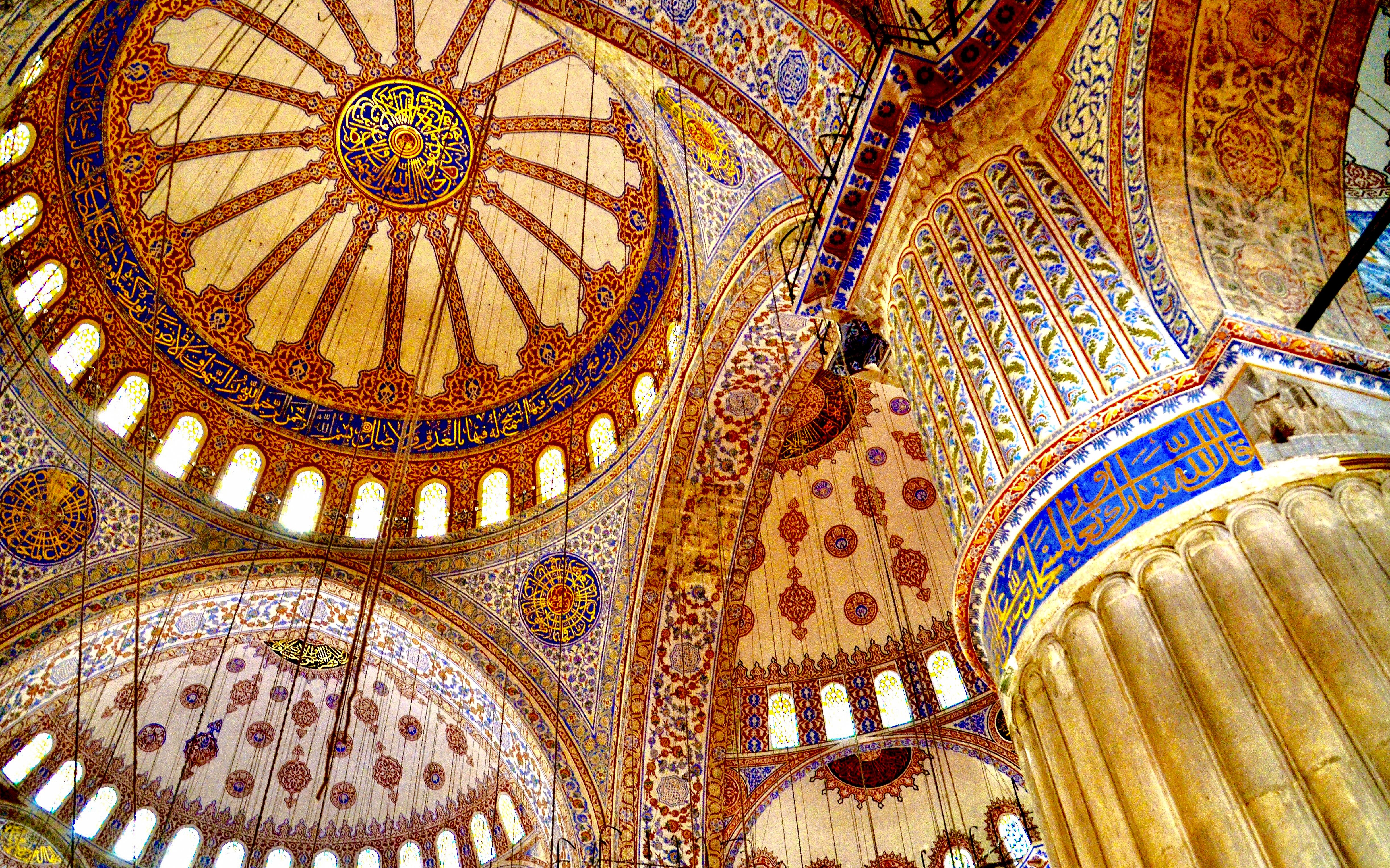 Ceiling of the Blue Mosque in Istanbul with intricate patterns and Arabic calligraphy.