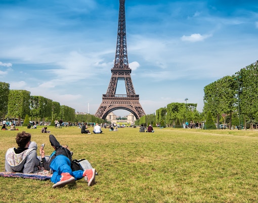 Picnic setup at Champ de Mars Gardens with Eiffel Tower in the background, Paris.