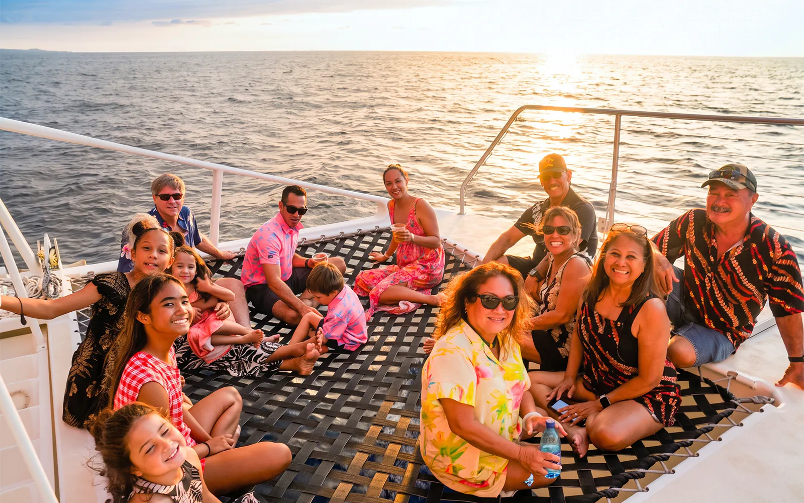 Group enjoying a sunset sail on a catamaran in Oahu, part of the Kaula Kai Sunset Sail experience.