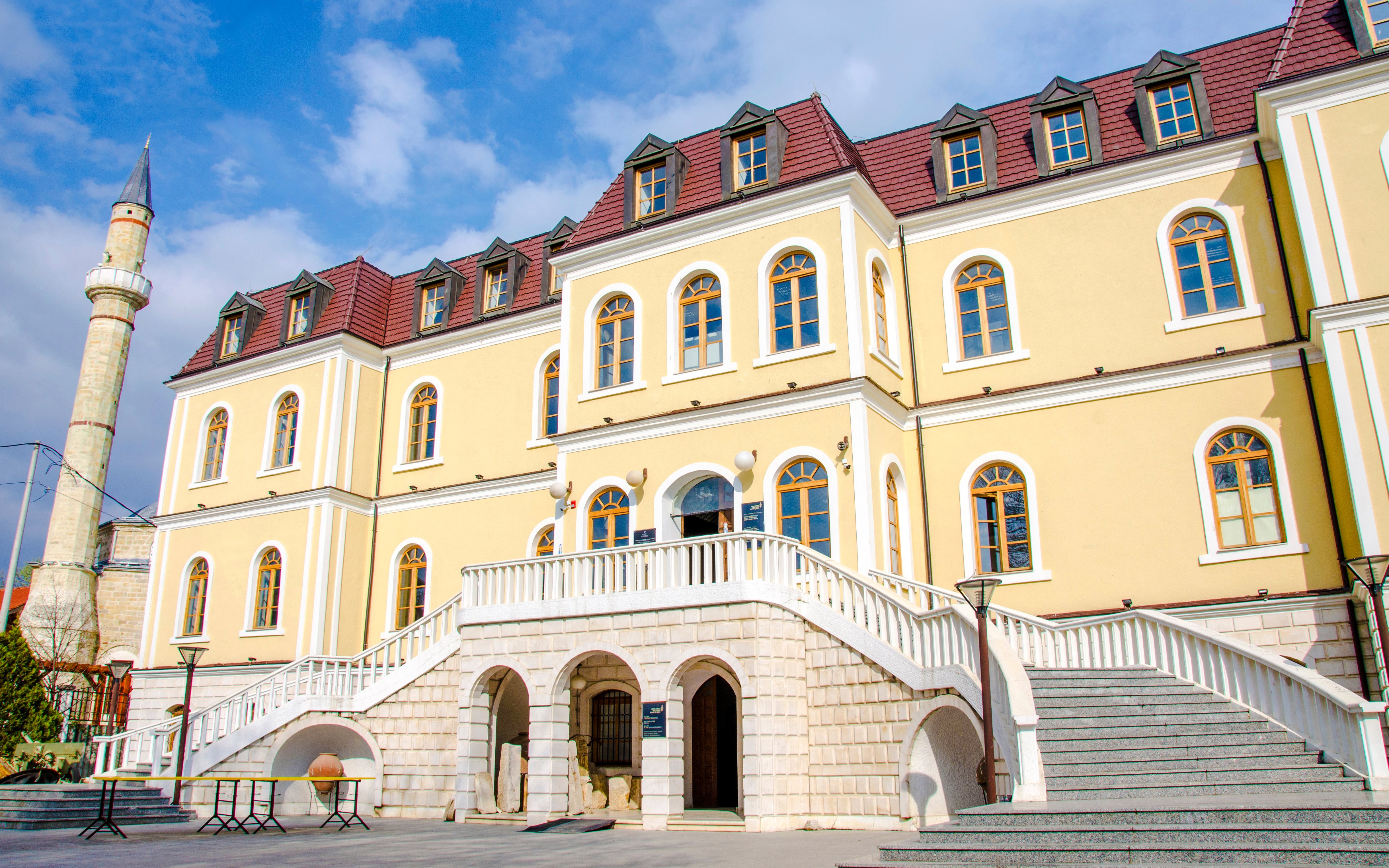 Kosovo Museum building with arched entrance and staircase in Pristina.
