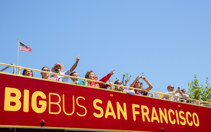 Tourists on San Francisco Big Bus tour with Alcatraz view.